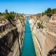 blue water flowing near rocky hills with bridge