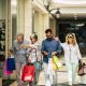 group of people going shopping together at the mall holding shopping bags - two seniors and couple of adults looking stores